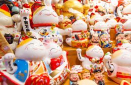Group of Maneki Neko displayed in shop – lucky cat, common Japanese lucky charm, talisman which is often believed to bring good luck to the owner, What is the Maneki Neko Cat?
