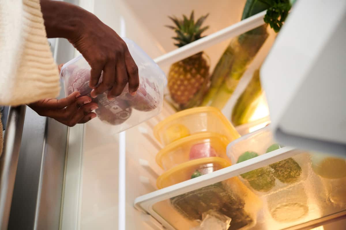 Woman putting leftovers in refrigerator